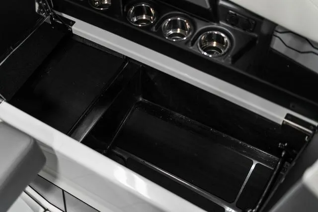 Slide: The Image of 2024 Malibu 23 LSV boat interior storage compartment with cup holders and seating. - 21