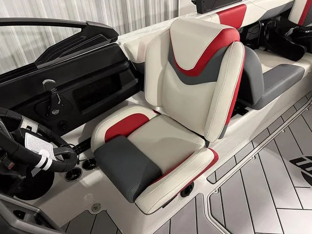 Slide: The Image of 2024 Malibu 23 LSV boat interior with red, gray, and white seating, and built-in speakers. - 33