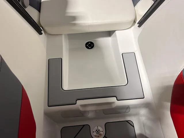 Slide: The Image of 2024 Malibu 23 LSV boat interior with red, gray, and white seating, cup holders, and speaker. - 35