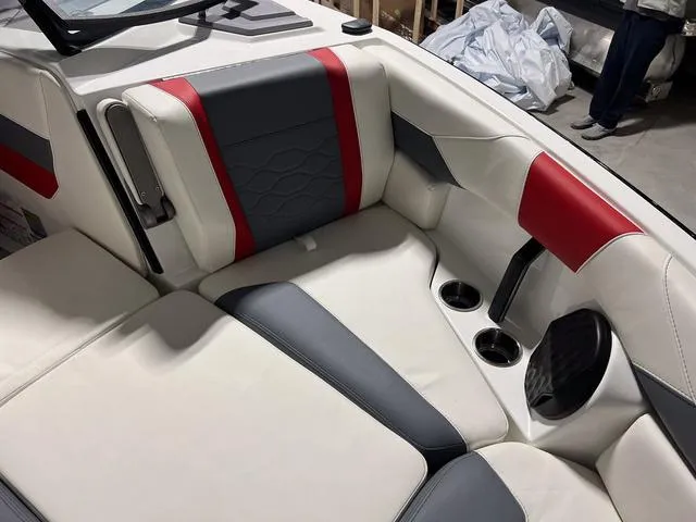 Slide: The Image of 2024 Malibu 23 LSV boat interior storage compartment with white and gray seating. - 38