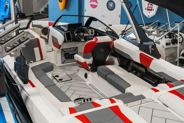 Slide: The Image of 2024 Malibu 23 LSV boat interior storage compartment with red, white, and gray seating. - 9