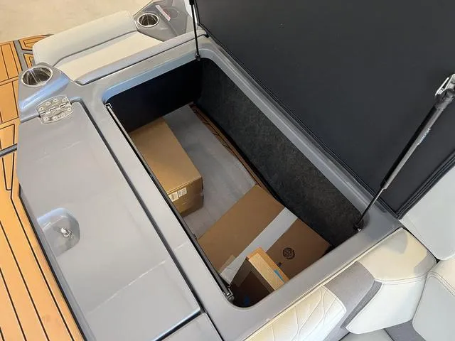 Slide: The Image of 2024 Nautique Super Air Nautique G23 storage compartment with boxes inside. - 14