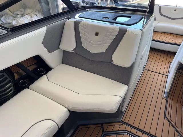 Slide: The Image of 2024 Nautique Super Air Nautique G23 interior with luxurious seating and teak flooring. - 22