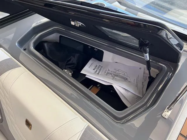 Slide: The Image of Storage compartment of 2024 Nautique Super Air Nautique G23 with manuals and accessories. - 30