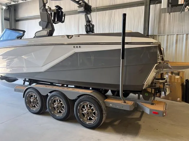 Slide: The Image of 2024 Nautique Super Air Nautique G23 boat on a triple-axle trailer in a warehouse. - 5