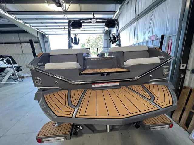 Slide: The Image of 2024 Nautique Super Air Nautique G23 boat rear view in a storage facility. - 8