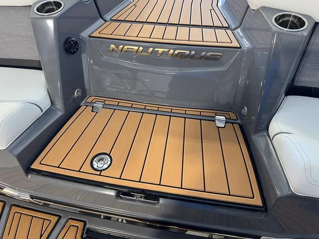 Slide: The Image of 2024 Nautique Super Air Nautique G23 boat deck with teak flooring and cup holders. - 9