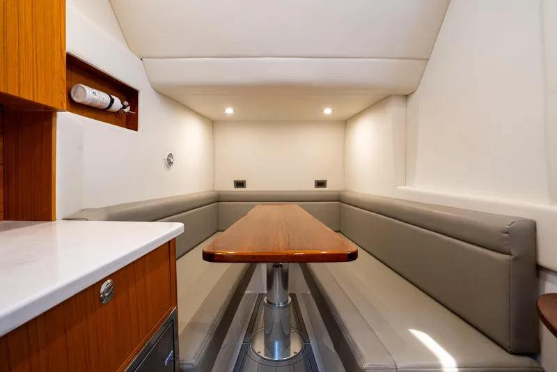 Slide: The Image of 2023 Front Runner 47 Center Console interior with sleek seating and wooden table. - 20