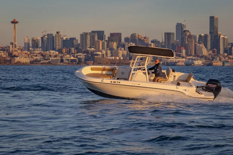 Slide: The Image of 2022 Bayliner Trophy T22CC boat cruising with city skyline in the background. - 3