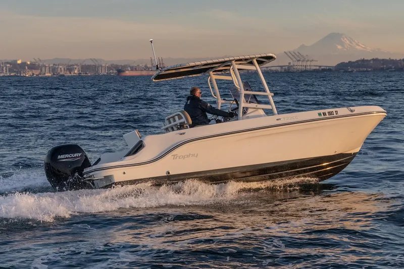 Slide: The Image of 2022 Bayliner Trophy T22CC boat cruising on open water with scenic mountain backdrop. - 9