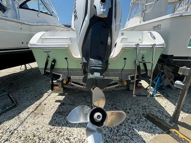 Slide: The Image of 2017 Sea Pro 219 Center Console boat with outboard motor, docked between other boats. - 2