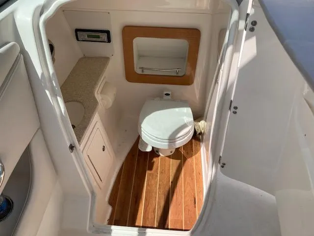 Slide: The Image of 2006 Chaparral 276 SSi boat interior bathroom with wooden flooring and compact design. - 4