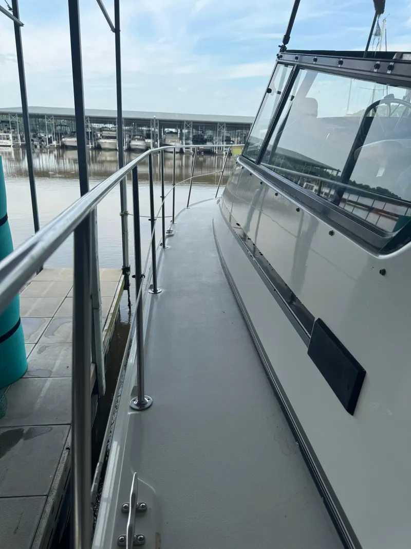 Slide: The Image of 1986 Carver 36 Mariner docked at a marina, side view of the deck and railing. - 10