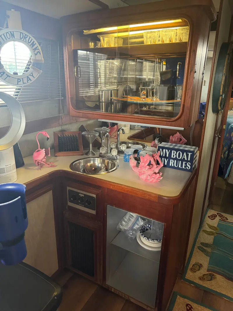 Slide: The Image of 1986 Carver 36 Mariner boat interior with kitchenette, sink, and decorative items. - 16