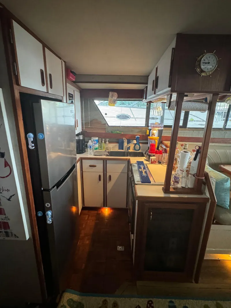 Slide: The Image of Interior kitchen of 1986 Carver 36 Mariner yacht with appliances and wooden cabinets. - 18