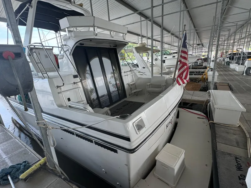 Slide: The Image of 1986 Carver 36 Mariner docked in a covered marina with American flag. - 2