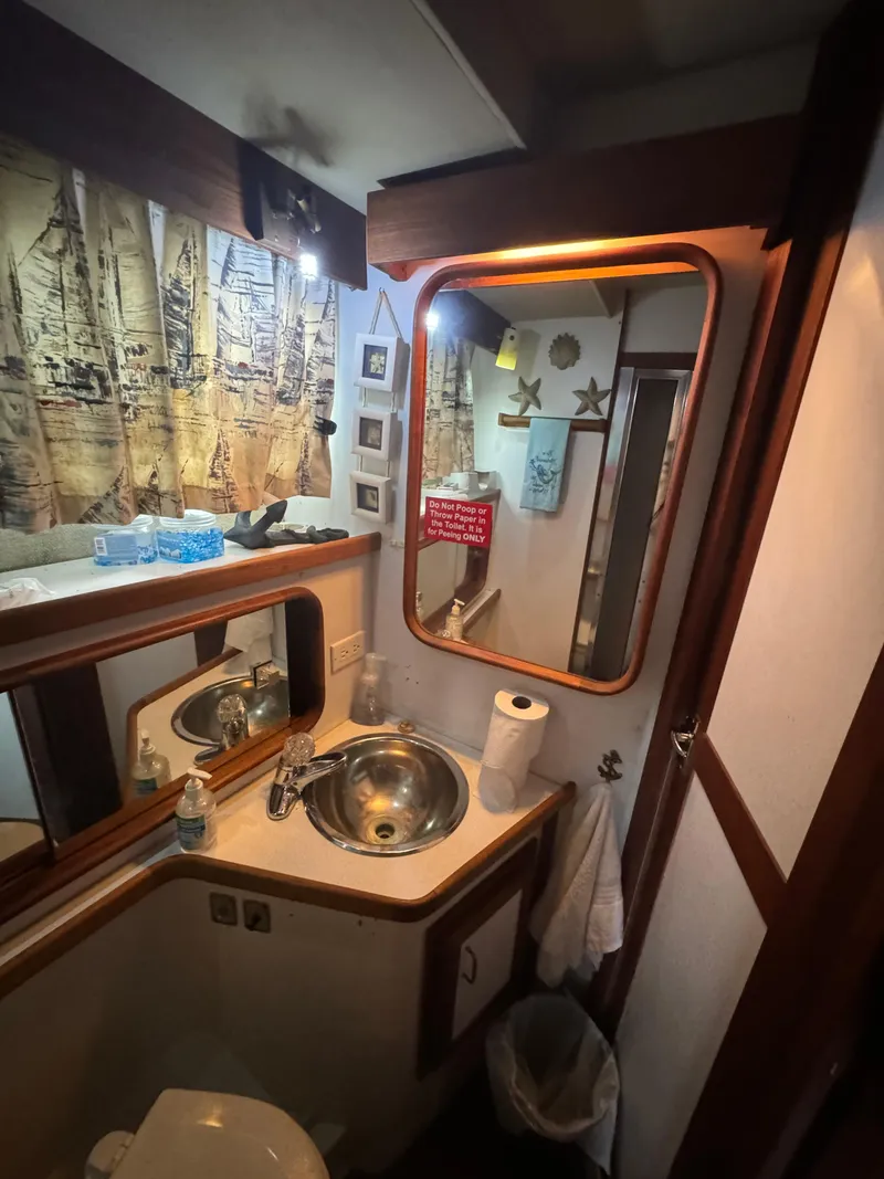 Slide: The Image of 1986 Carver 36 Mariner bathroom with sink, mirror, and nautical decor. - 22