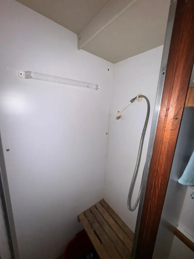 Slide: The Image of Shower area in 1986 Carver 36 Mariner boat with wooden bench and handheld showerhead. - 23
