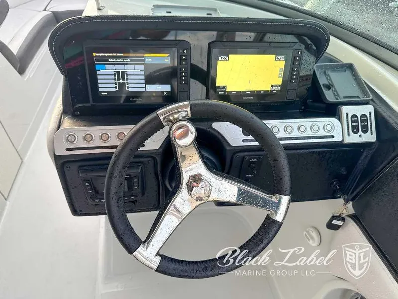 Slide: The Image of 2024 Finseeker 240 DC boat dashboard with steering wheel and dual Garmin displays. - 7