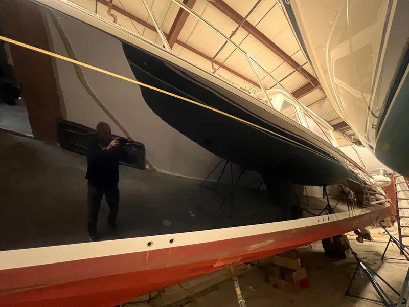 Slide: The Image of 2013 MJM 40z Downeast boat in storage, sleek black hull, indoor setting. - 12