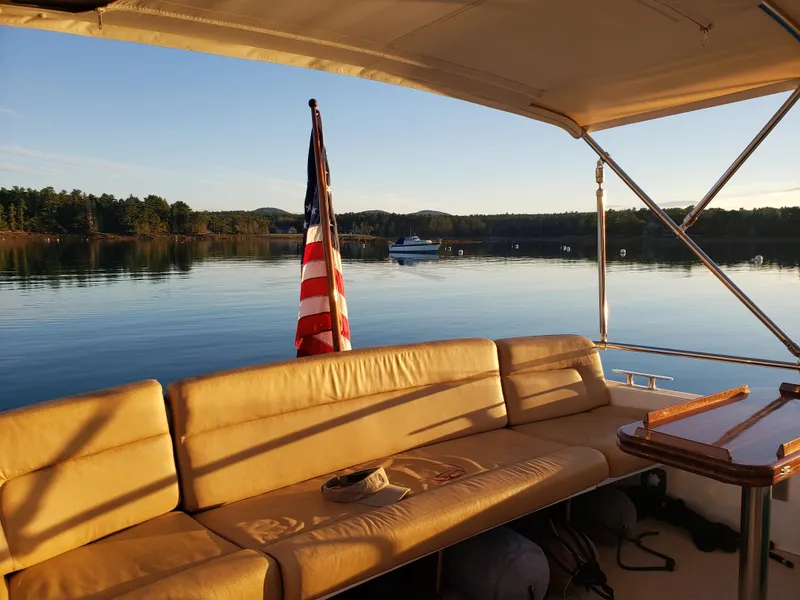 Slide: The Image of 2013 MJM 40z Downeast boat interior with American flag, serene lake view. - 32