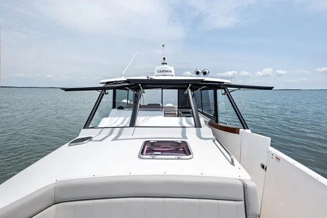 Slide: The Image of 2013 MJM 40z boat floating on calm water, reflecting sunlight. - 41