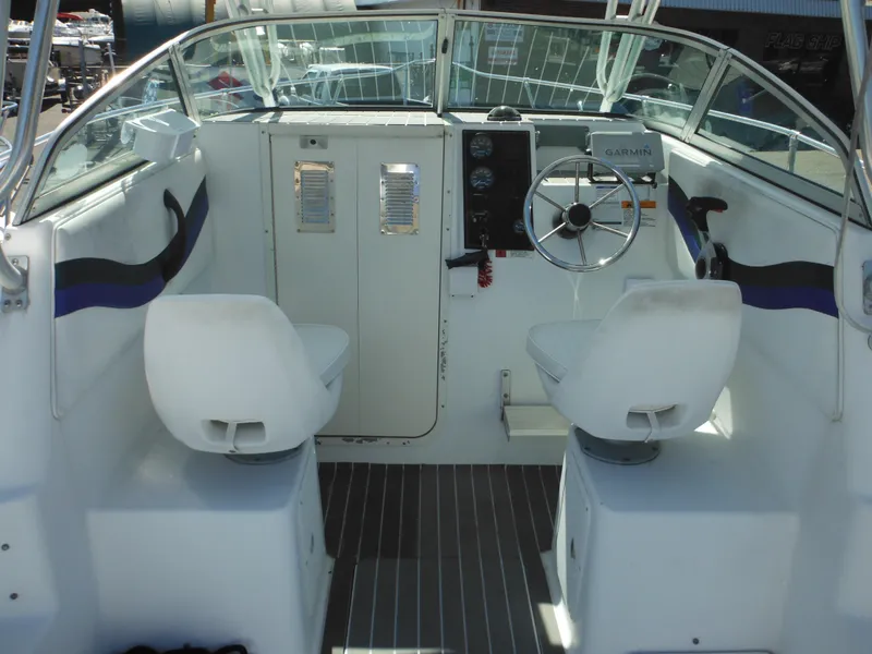 Slide: The Image of 2000 Seaswirl 2300 Walk Around boat cockpit with dual seats and steering console. - 17