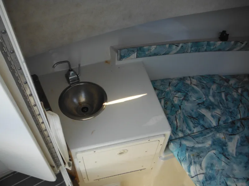 Slide: The Image of Interior of 2000 Seaswirl 2300 Walk Around boat with sink and cushioned seating. - 25