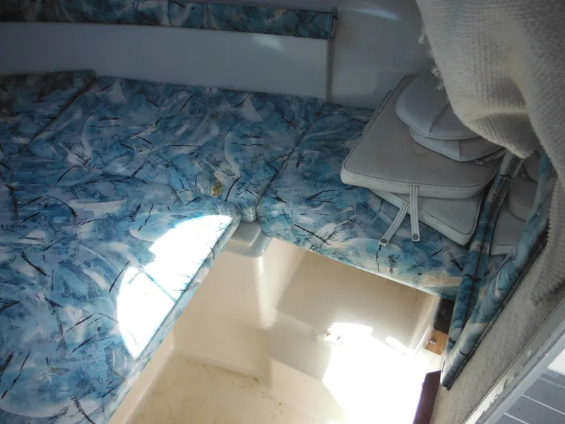 Slide: The Image of Interior cabin of 2000 Seaswirl 2300 Walk Around boat with blue patterned cushions. - 26
