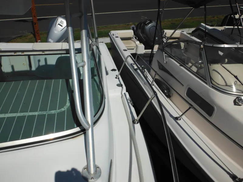 Slide: The Image of 2000 Seaswirl 2300 Walk Around boat docked next to another boat. - 33