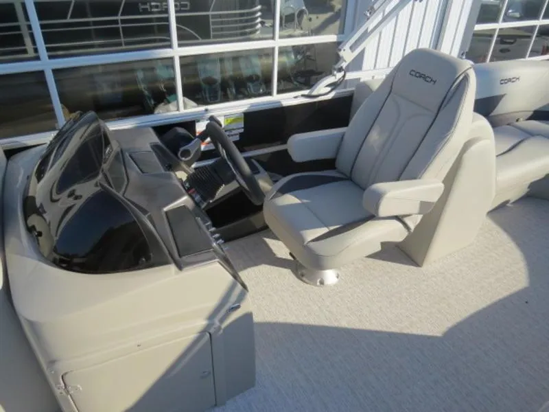 Slide: The Image of 2023 Coach Pontoons 243 RFC helm station with captain's chair and steering wheel. - 11