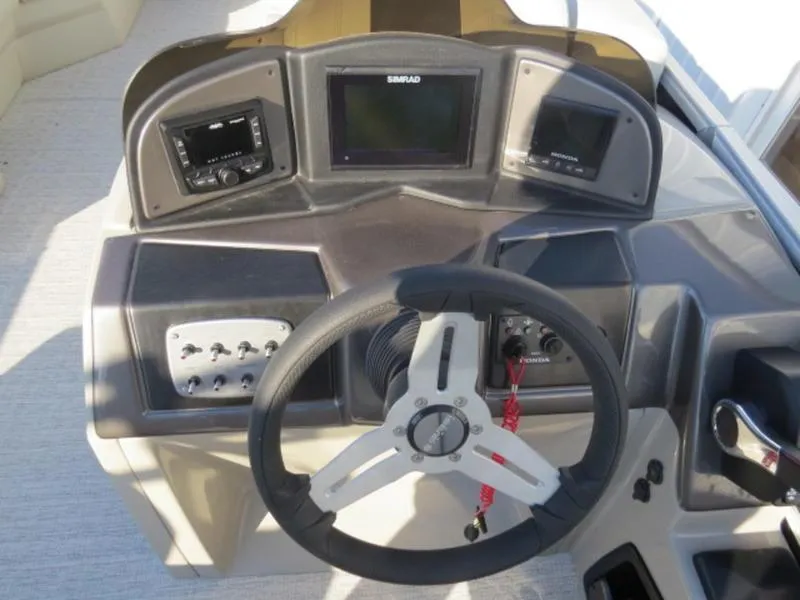 Slide: The Image of 2023 Coach Pontoons 243 RFC dashboard with steering wheel and control panel. - 13