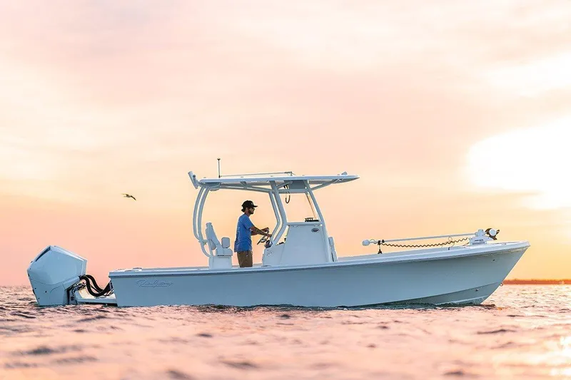 Slide: The Image of 2027 Pair Customs 24DV boat cruising at sunset with a person onboard. - 4