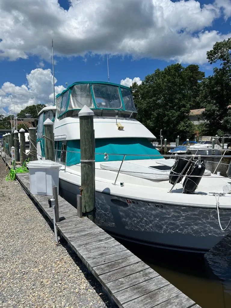 Slide: The Image of 1994 Carver 355 Aft Cabin yacht docked at a marina on a sunny day. - 2