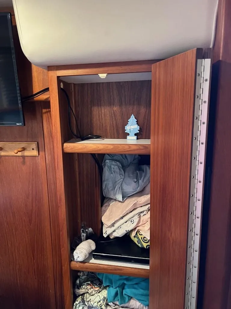 Slide: The Image of Open wooden cabinet with clothes and air freshener in 1994 Carver 355 Aft Cabin. - 23