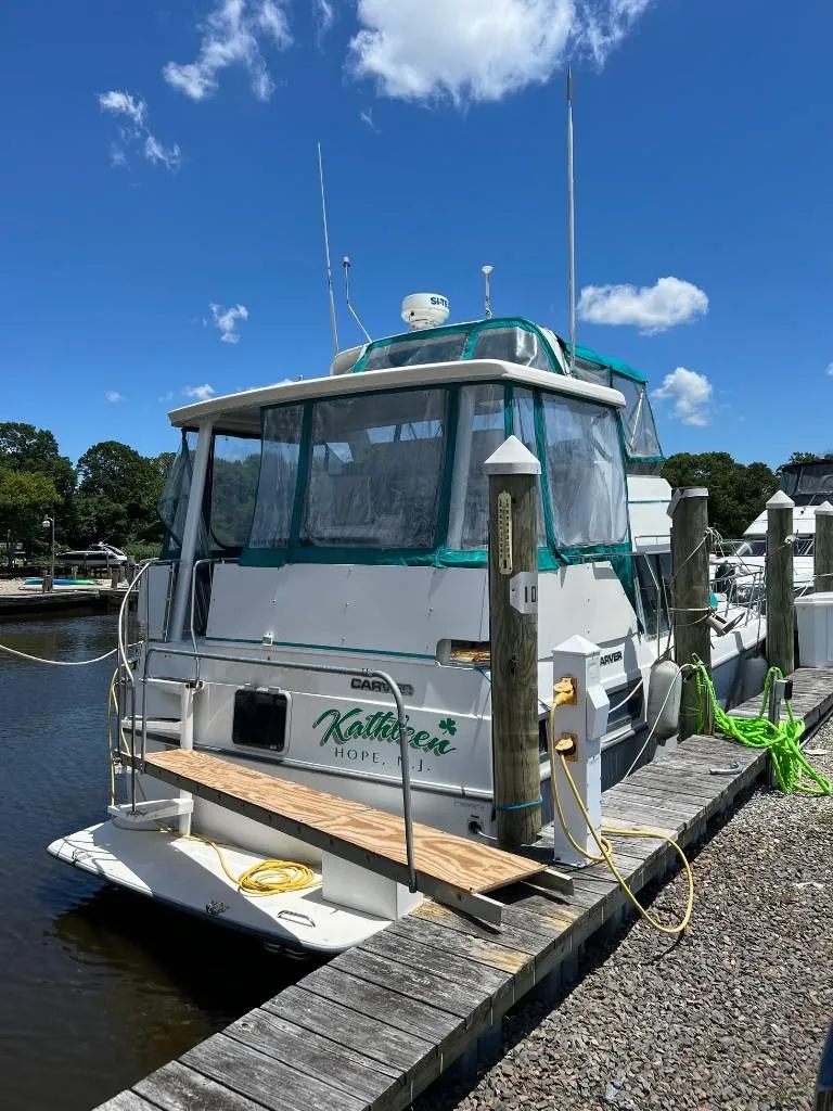 Slide: The Image of 1994 Carver 355 Aft Cabin yacht docked at a marina on a sunny day. - 3