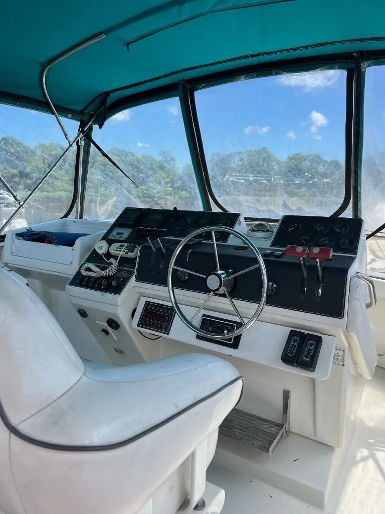 Slide: The Image of 1994 Carver 355 Aft Cabin helm with steering wheel and control panel. - 4