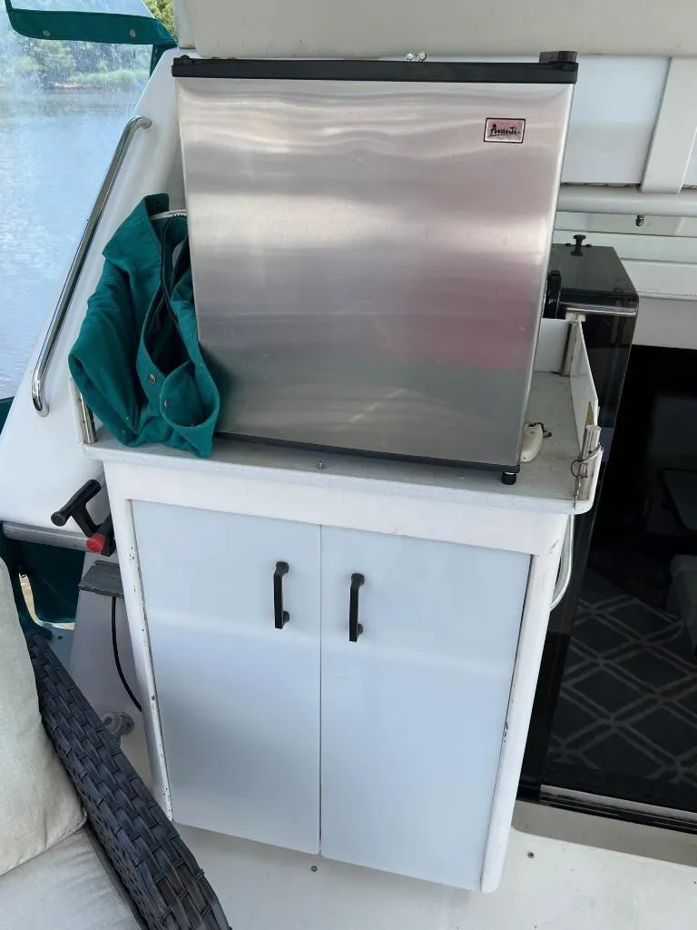 Slide: The Image of 1994 Carver 355 Aft Cabin with mini fridge and storage cabinet on deck. - 8