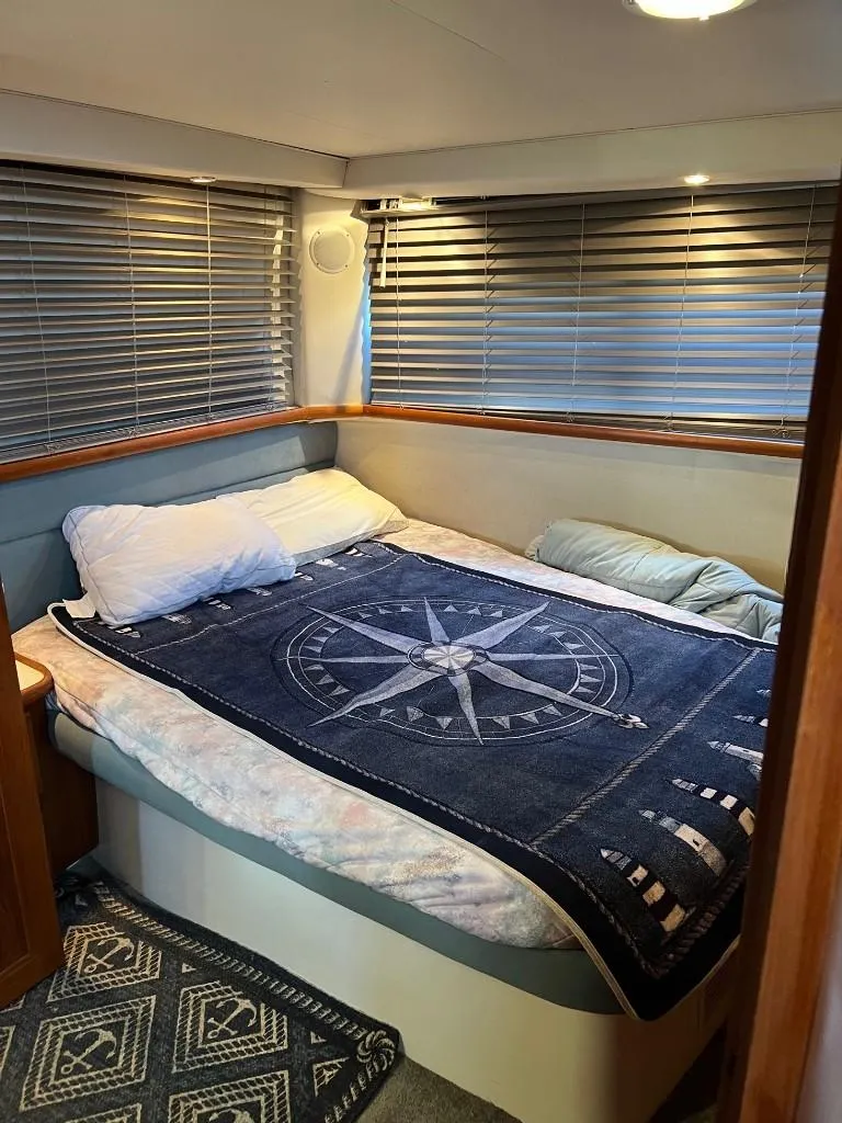 Slide: The Image of Cozy bedroom in a 1994 Carver 355 Aft Cabin yacht with nautical-themed bedding. - 21