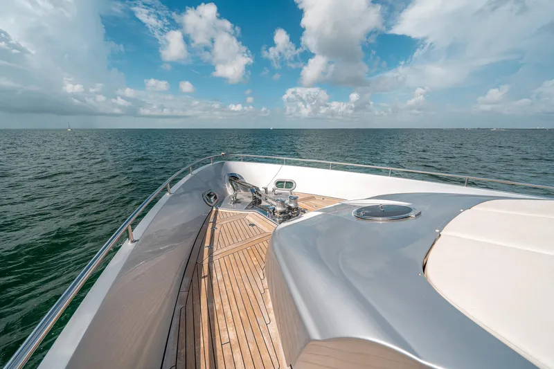 Slide: The Image of 2012 Pershing 92 yacht bow with teak deck and ocean view under blue sky. - 37