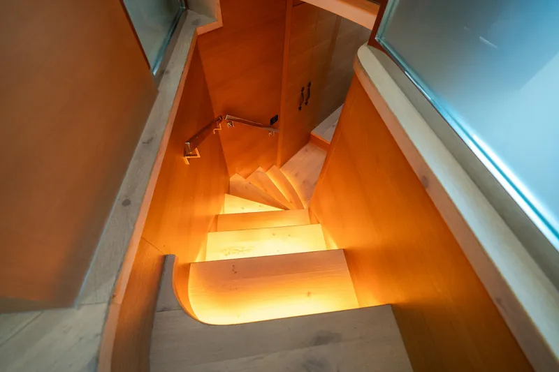 Slide: The Image of Wooden staircase inside 2012 Pershing 92 yacht, warm lighting, modern design. - 49