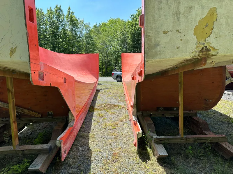 Slide: The Image of Two Young Brothers 2020 hull molds on wooden supports, outdoors with trees in the background. - 10