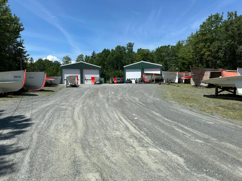 Slide: The Image of Outdoor storage area with Young Brothers 2020 hull molds and two large sheds. - 13