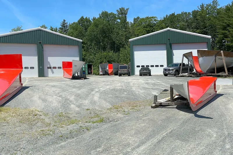 Slide: The Image of Outdoor view of Young Brothers 2020 hull molds with red accents near green warehouses. - 15