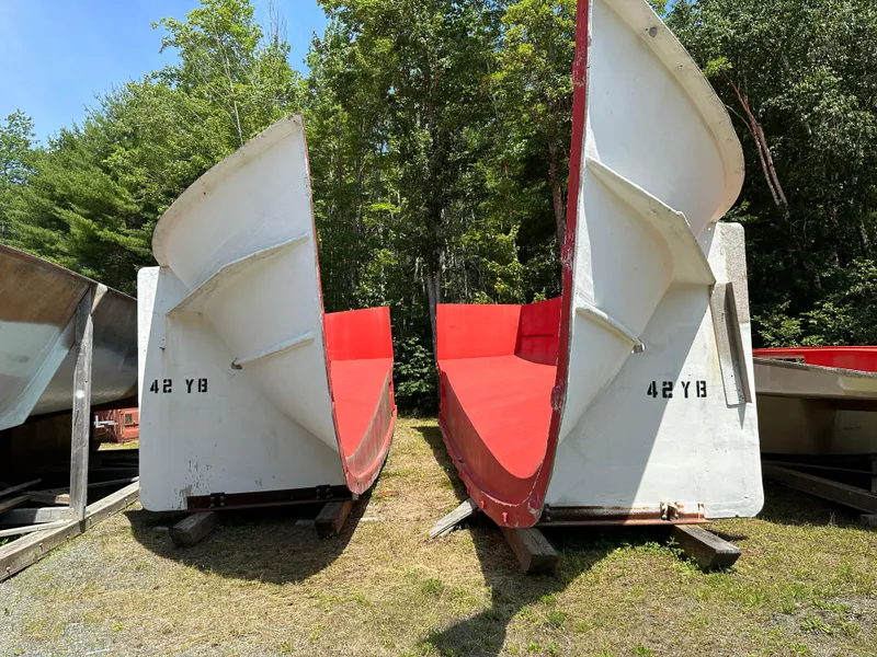 Slide: The Image of Two 2020 Young Brothers hull molds, red and white, displayed outdoors. - 5