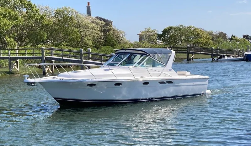 Slide: The Image of 2002 Tiara Yachts 3100 Open cruising on a calm river near a wooden bridge. - 0