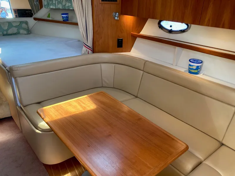 Slide: The Image of Interior of 2002 Tiara Yachts 3100 Open with beige seating and wooden table. - 6
