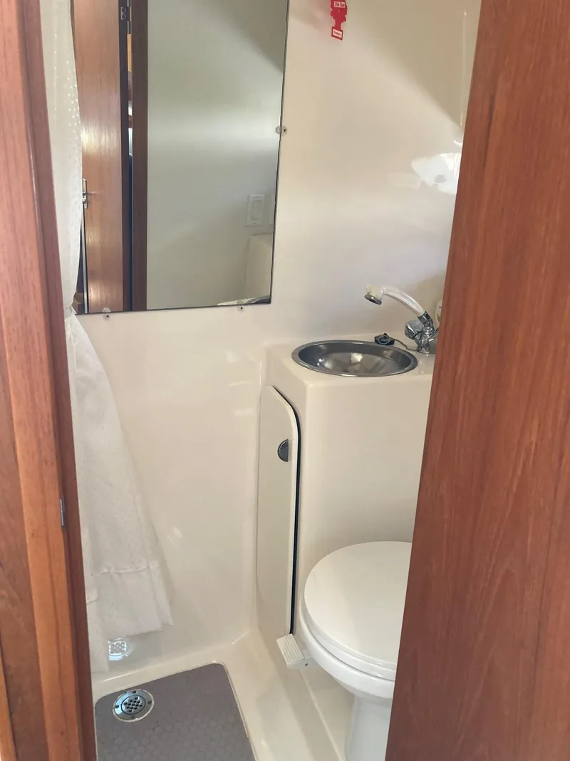 Slide: The Image of 2002 Tiara Yachts 3100 Open bathroom with sink, toilet, and mirror. - 8