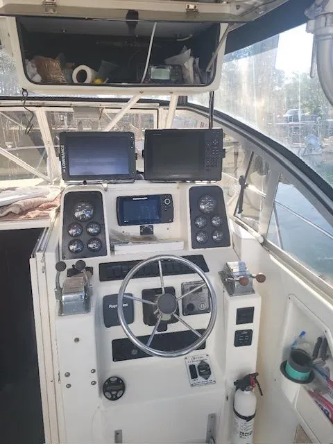 Slide: The Image of 1999 Shamrock 290 Walkaround boat helm with navigation equipment and steering wheel. - 11