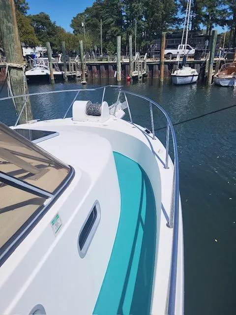 Slide: The Image of 1999 Shamrock 290 Walkaround boat docked at a marina. - 13